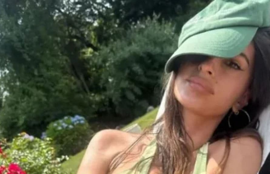 Emily Ratajkowski pozon para kamerës teksa merr rreze dielli