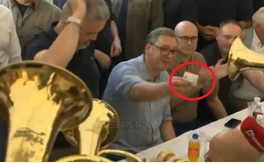 I frikësuar me protestat e studentëve, Vuçiqi mundohet të festojë me këngë çetnike, i qet edhe dinar muzikantit